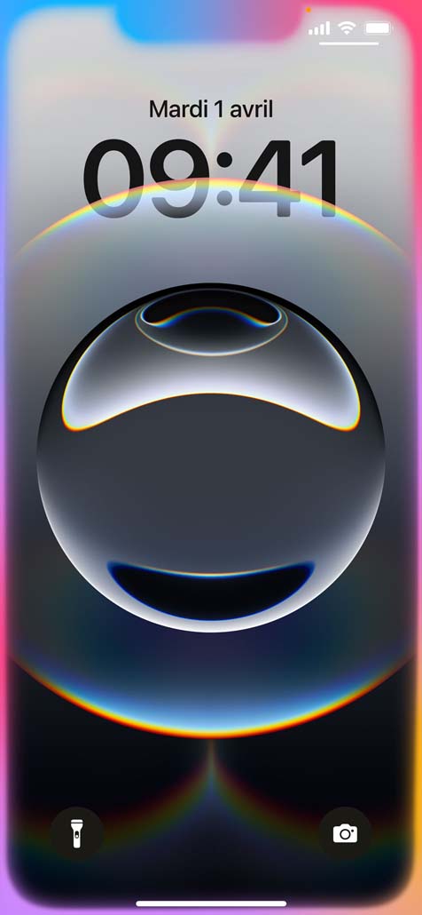 Une main tient un iPhone seize-e. Les bords de l’écran verrouillé brillent de différentes couleurs.