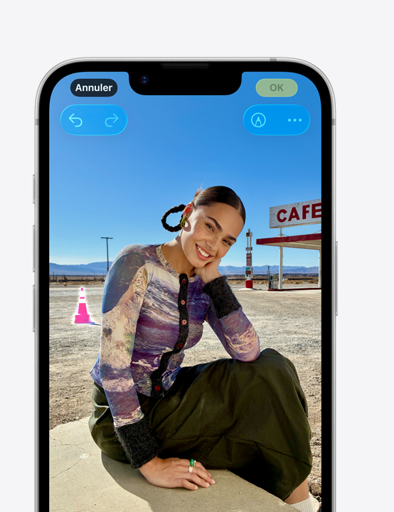 Écran d’iPhone, photo d’une personne qui sourit sur la plage, montrant comment effacer un cône dans l’arrière-plan avec l’outil de nettoyage