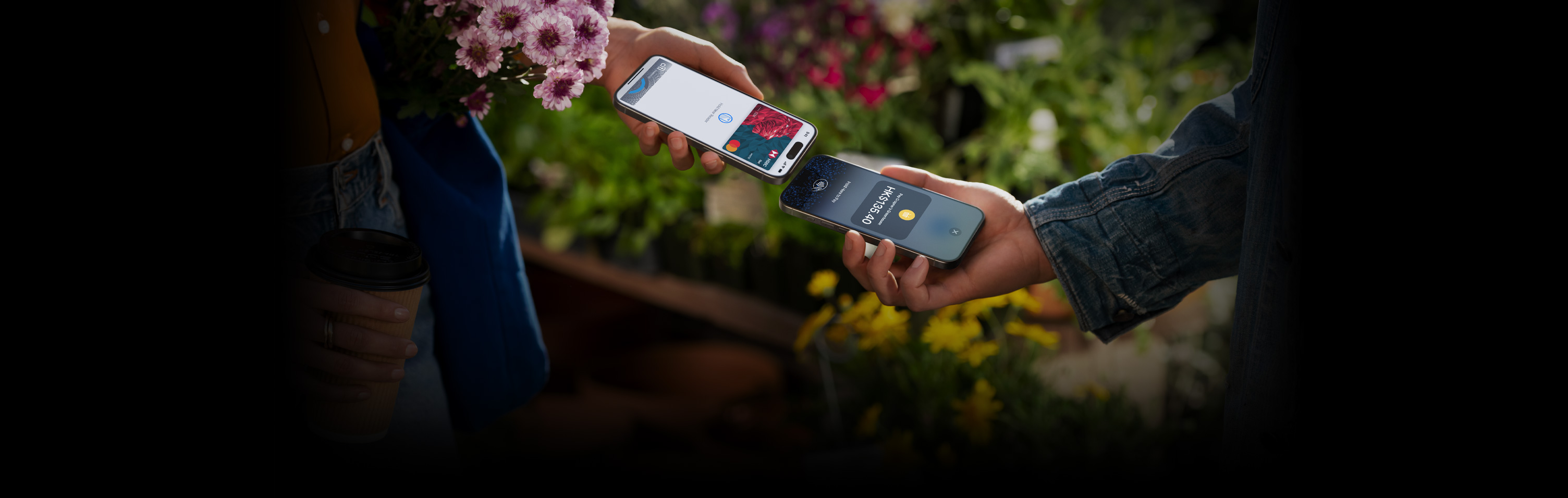 圖片顯示兩個人手持 iPhone 完成交易。