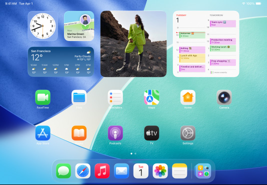 iPad, three models, landscape orientation, with center model in front of two others, Apple Pencil magnetically attached to top of center model, center screen showing the Home Screen featuring colorful app icons with Liquid Glass effect, left screen showing the Preview app, right screen showing Home Screen with files fanning out from the dock