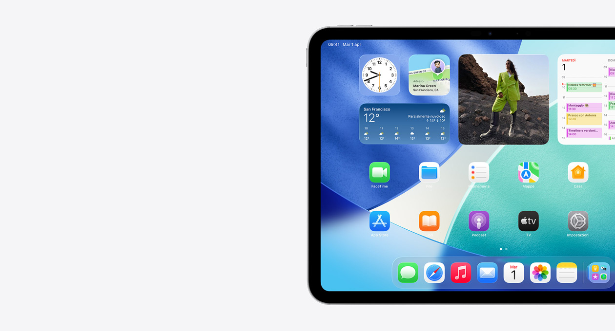 Un iPad in orizzontale, parte sinistra dello schermo, schermata Home con widget tra cui un orologio traslucido che mostra l’effetto Liquid Glass, l’app Dov’è, il widget Meteo, due file di app più piccole e il Dock