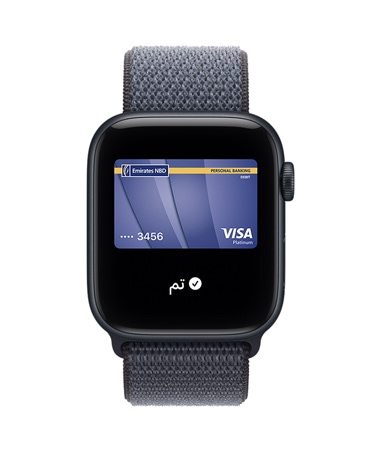 Apple Watch SE 3 بإطار من الألومنيوم ولون سماء الليل، وApple Pay في تطبيق المحفظة من Apple، والجزء الخارجي الأيمن يُظهِر التاج الرقمي، وحزام Loop رياضي بلون أزرق حديدي
