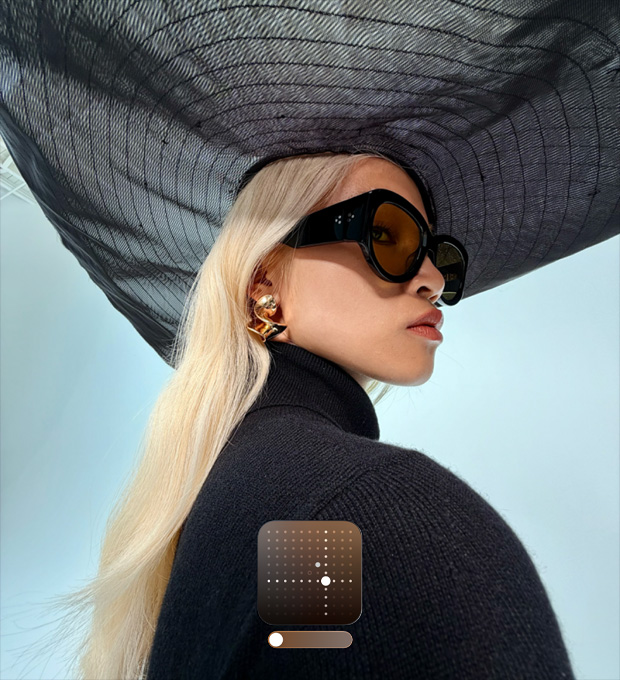 صورة لسيدة ترتدي قبعة سوداء واسعة الحواف تُظهر نمط ساطع في الصور الذي يزيد سطوع الصور المصورة في ظروف الإضاءة المنخفضة أو في النمط الليلي