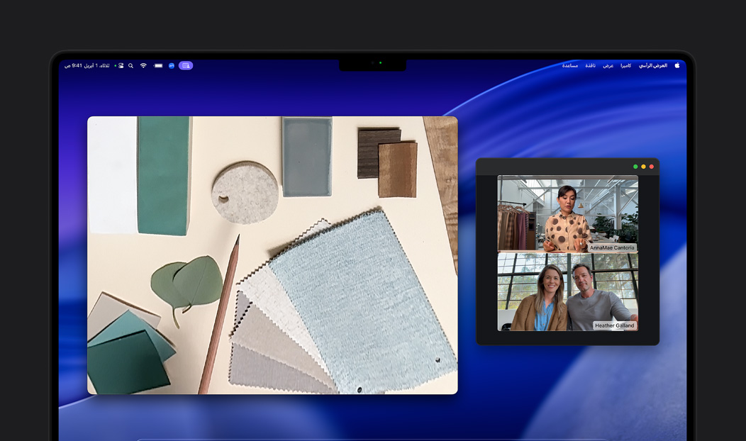 مكالمة فيديو على MacBook Pro لامرأة تستخدم ميزة العرض الرأسي لعرض مساحة عملها المليئة بقطع الأقمشة لشخصين في المكالمة، تتيح لها ميزة العرض الرأسي إظهار مساحة عملها ووجهها في الوقت نفسه