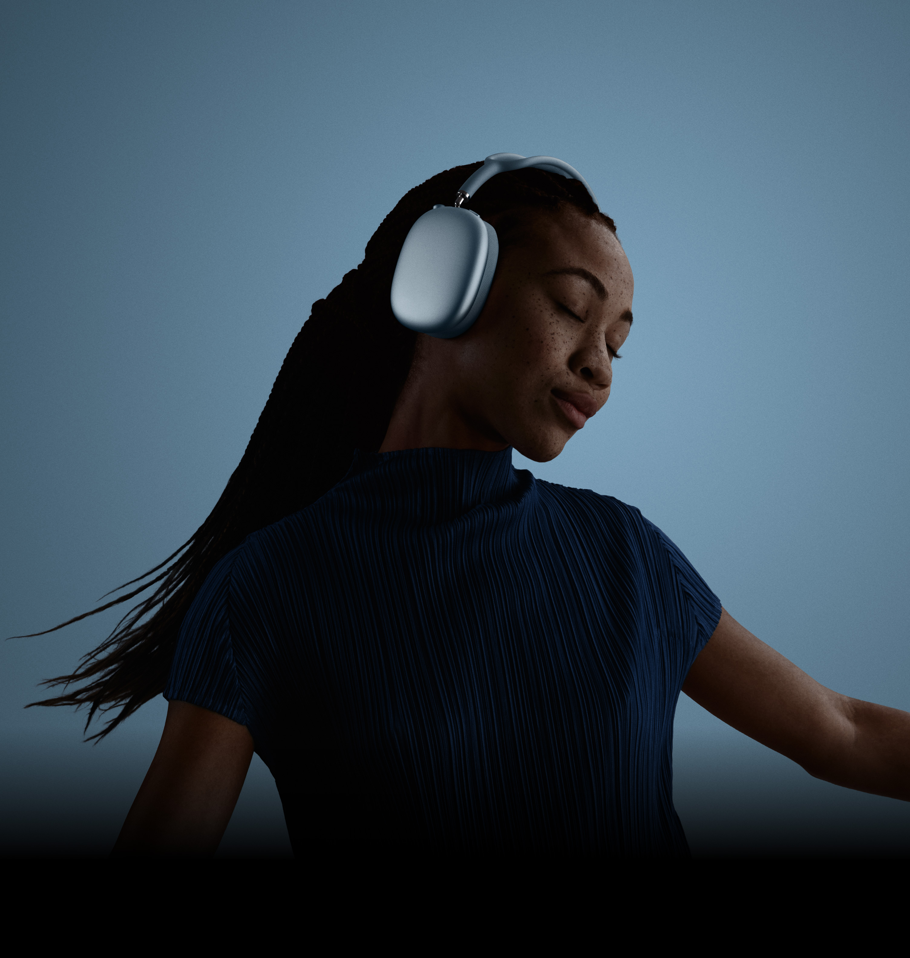 Žena s nasazenými AirPody Max, zavřenýma očima a hlavou nakloněnou doleva.