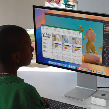 Une femme assise à un bureau travaille dans Excel sur Mac. Le fichier contient un tableau de suivi des ventes du quatrième trimestre. En arrière-plan, une fenêtre Pixelmator Pro est ouverte.