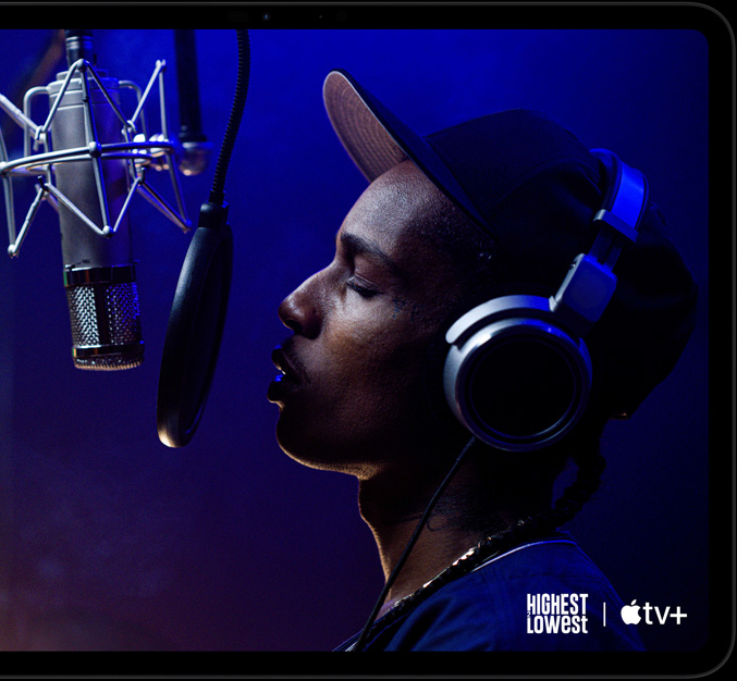 جهاز iPad Pro، الوضع الأفقي، الجزء الأمامي الخارجي، لون أسود فلكي، زوايا مدورة، إطار شاشة أسود، شاشة تُظهر +Apple TV يعرض مشهداً من فيلم Highest 2 Lowest من أعمال +Apple TV الأصلية مع الفنان ASAP Rocky بدور Yung Felon يغني الراب أمام ميكروفون