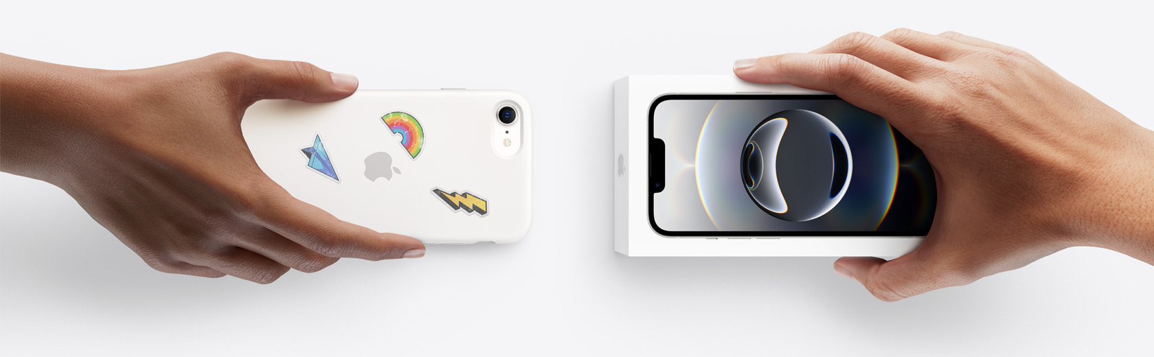 Hænder, der bytter en gammel iPhone til en ny iPhone 16e i en æske.